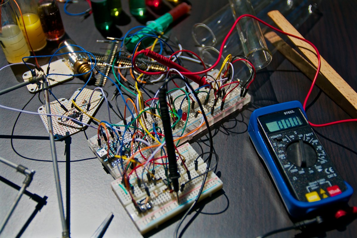 Circuit boards and a multimeter on a repair bench