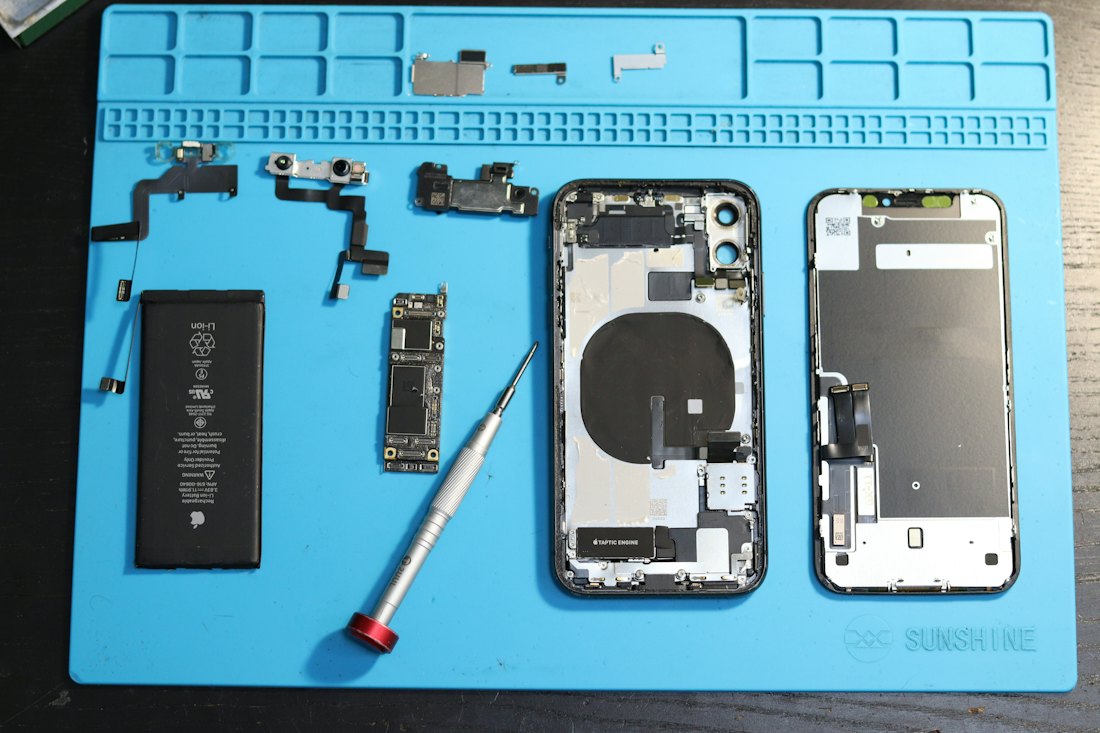 A smartphone taken apart on a repair mat